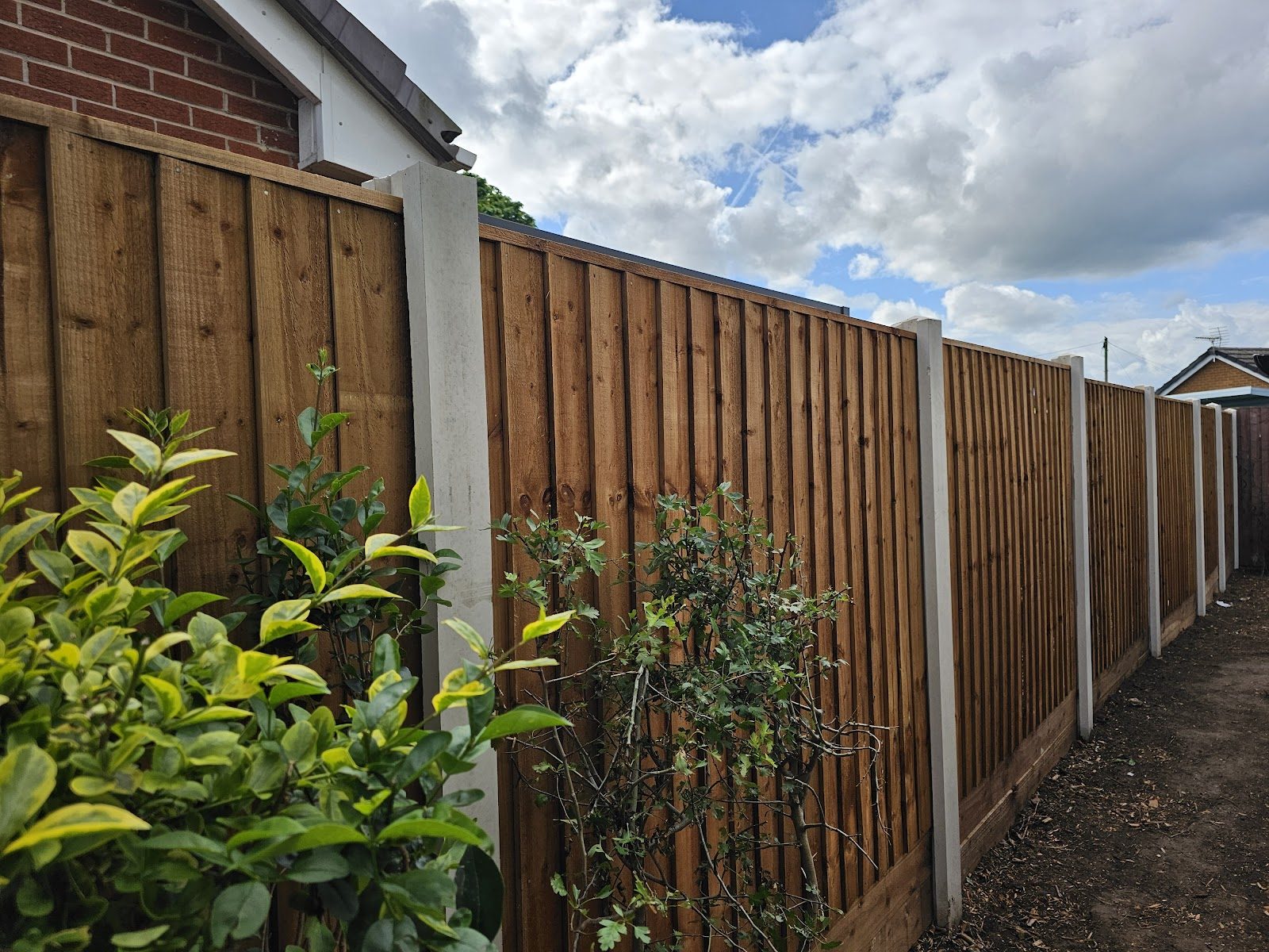 Close-board feather-edge fence run on concrete posts
