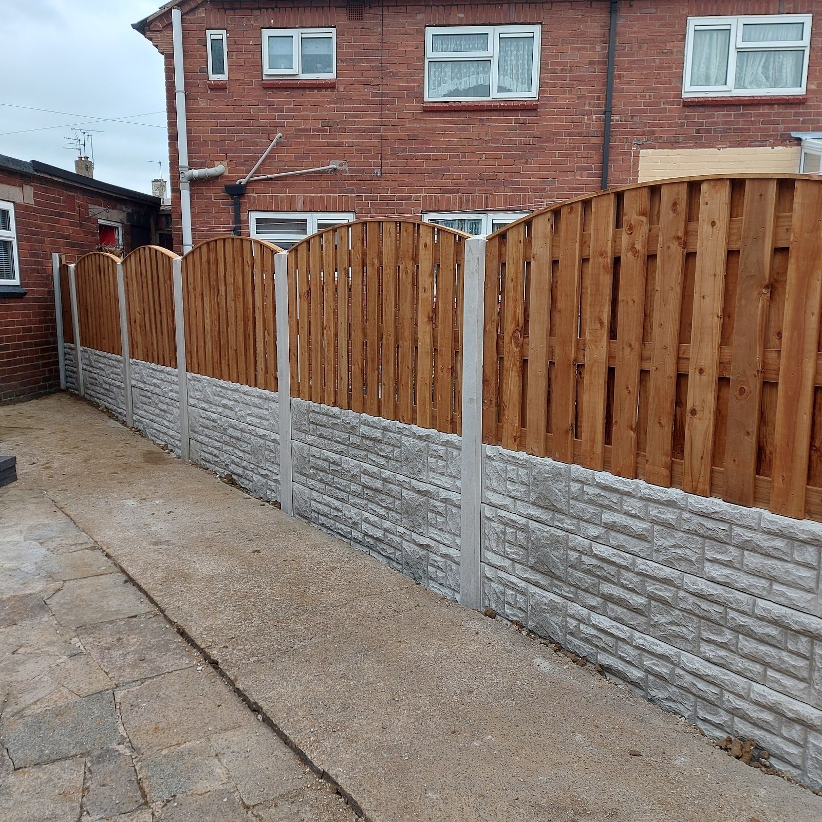 Arched-top fence panels on decorative stone-effect gravel boards